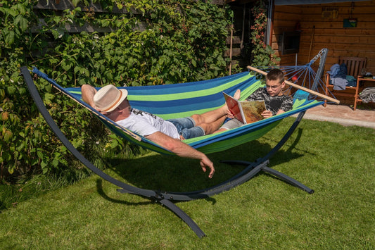 "Geniet samen in de tuin van een groen/blauw gestreepte Acadia 2-persoons hangmat met een grafiet frame."