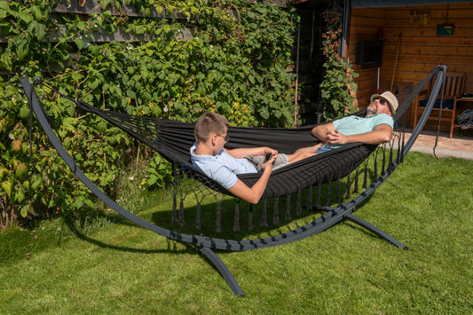 "Robuust frame met luxe 2-persoons zwarte hangmat met franje voor optimaal comfort."