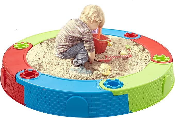 Kleurrijke ronde plastic zandbak buiten met worteldoek, een kind speelt vrolijk in het zand. Perfect voor buitenspelen.