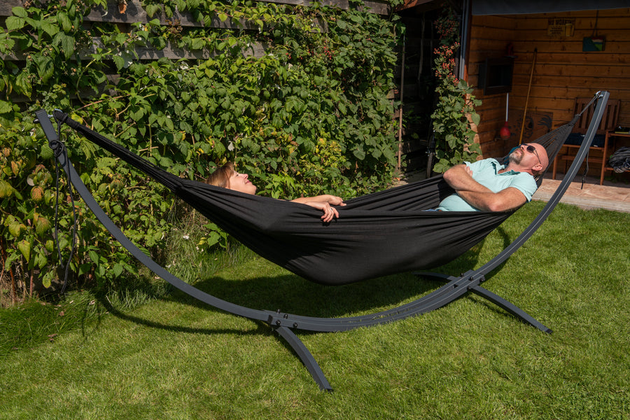 "Fijn in de tuin: Zwarte hangmat met verzinkt metalen frame en standaard voor ontspannen momenten."