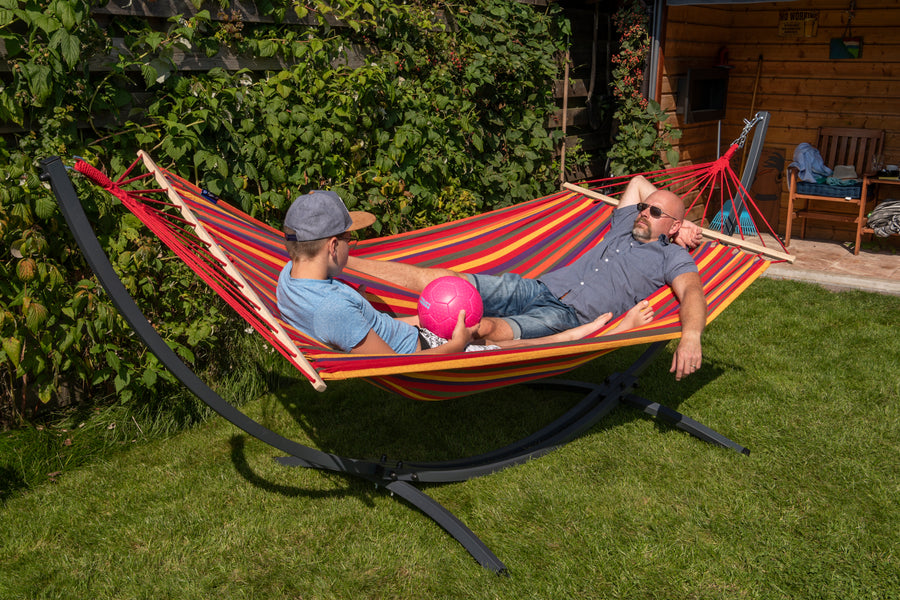 "Geniet samen in de tuin van een rood gestreepte Acadia 2-persoons hangmat met een grafiet frame."  