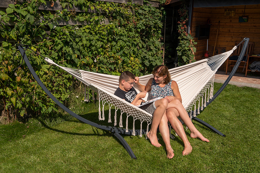 "Fijn in de tuin:franje creme hangmat met verzinkt metalen frame en standaard voor ontspannen momenten."